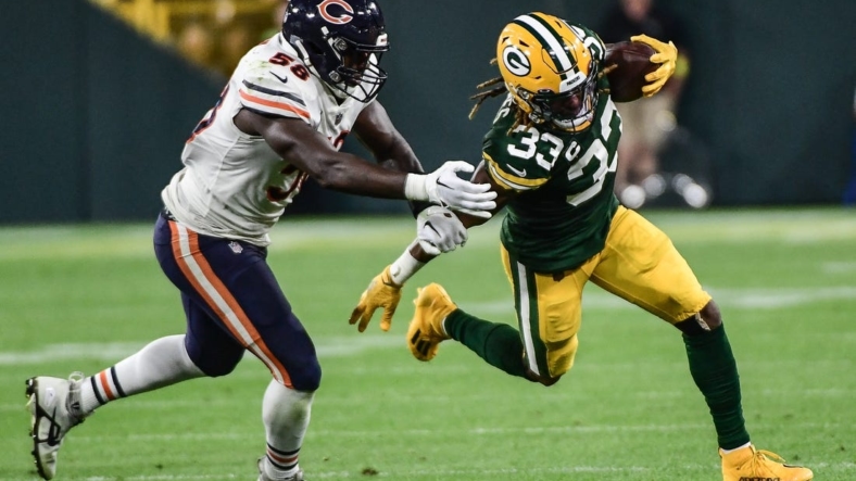 Sep 18, 2022; Green Bay, Wisconsin, USA; Green Bay Packers running back Aaron Jones (33) tries to break a tackle by Chicago Bears linebacker Roquan Smith (58) in the second quarter at Lambeau Field. Mandatory Credit: Benny Sieu-USA TODAY Sports