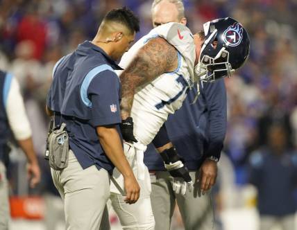 Sep 19, 2022; Orchard Park, New York, USA; Tennessee Titans offensive tackle Taylor Lewan (77) is helped off the field during the first quarter against the Buffalo Bills at Highmark Stadium. Mandatory Credit: George Walker IV -USA TODAY Sports