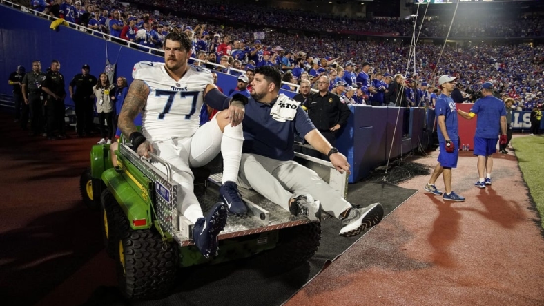 Sep 19, 2022; Orchard Park, New York, USA; Tennessee Titans offensive tackle Taylor Lewan (77) is helped from the field after getting an injury during the first quarter against the Buffalo Bills at Highmark Stadium  Mandatory Credit: George Walker IV -USA TODAY Sports