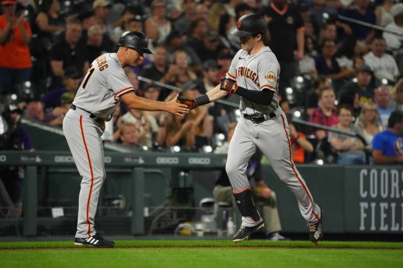Sep 19, 2022; Denver, Colorado, USA; San Francisco Giants center fielder Mike Yastrzemski (5) is congratulated for his solo home run by third base coach Mark Hallberg (91) in the fourth inning against the Colorado Rockies at Coors Field. Mandatory Credit: Ron Chenoy-USA TODAY Sports