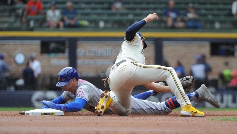 Sep 21, 2022; Milwaukee, Wisconsin, USA;  New York Mets center fielder Brandon Nimmo (9) slides into second base safely ahead of the tag from Milwaukee Brewers shortstop Willy Adames (27) in the first inning at American Family Field. Mandatory Credit: Michael McLoone-USA TODAY Sports
