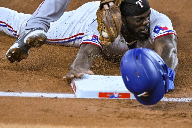 Sep 21, 2022; Arlington, Texas, USA; Texas Rangers designated hitter Adolis Garcia (53) is tagged out after he caught attempting to steal third base during the third inning against the Los Angeles Angels at Globe Life Field. Mandatory Credit: Jerome Miron-USA TODAY Sports