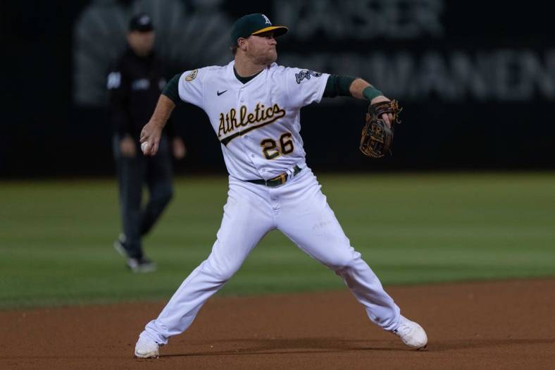 Sep 21, 2022; Oakland, California, USA;  Oakland Athletics third baseman Sheldon Neuse (26) throws the baseball during the seventh inning against the Seattle Mariners at RingCentral Coliseum. Mandatory Credit: Stan Szeto-USA TODAY Sports