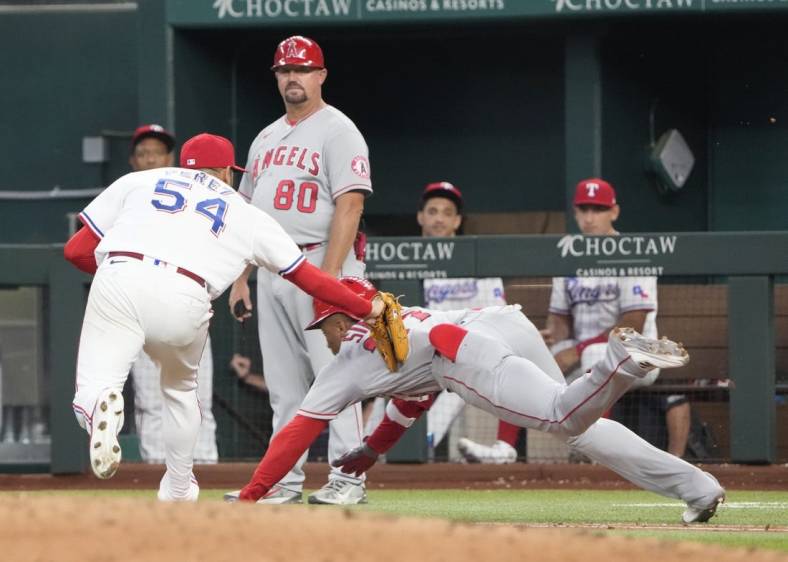 Sep 22, 2022; Arlington, Texas, USA; Texas Rangers starting pitcher Martin Perez (54) tags out Los Angeles Angels center fielder Magneuris Sierra (37) during the fourth inning at Globe Life Field. Mandatory Credit: Jim Cowsert-USA TODAY Sports