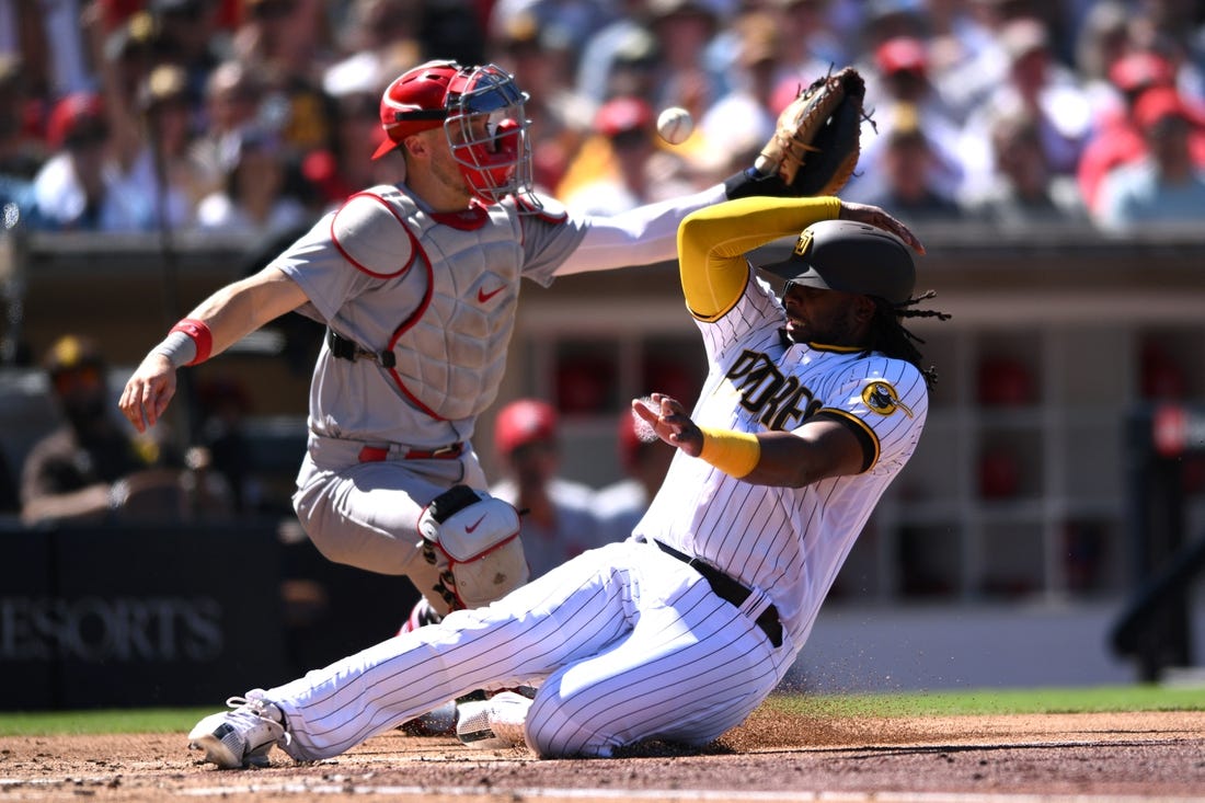 Sep 22, 2022; San Diego, California, USA; San Diego Padres designated hitter Josh Bell (right) slides home to score a run ahead of the throw to St. Louis Cardinals catcher Andrew Knizner (left) during the second inning at Petco Park. Mandatory Credit: Orlando Ramirez-USA TODAY Sports