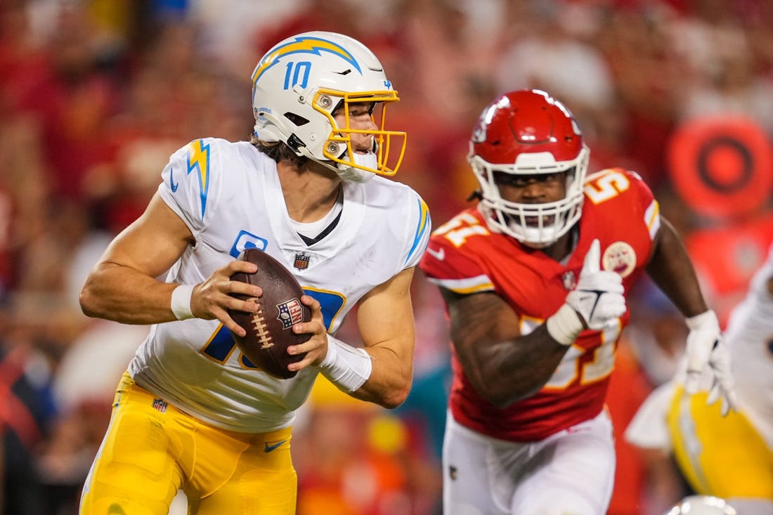 Sep 15, 2022; Kansas City, Missouri, USA; Los Angeles Chargers quarterback Justin Herbert (10) from Kansas City Chiefs defensive end Mike Danna (51) during the second half at GEHA Field at Arrowhead Stadium. Mandatory Credit: Jay Biggerstaff-USA TODAY Sports