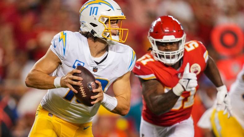 Sep 15, 2022; Kansas City, Missouri, USA; Los Angeles Chargers quarterback Justin Herbert (10) from Kansas City Chiefs defensive end Mike Danna (51) during the second half at GEHA Field at Arrowhead Stadium. Mandatory Credit: Jay Biggerstaff-USA TODAY Sports