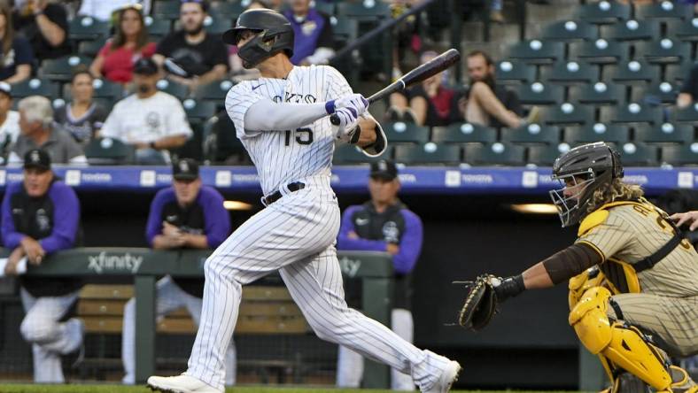 Sep 23, 2022; Denver, Colorado, USA; Colorado Rockies right fielder Randal Grichuk (15) hits a single during the first inning against the San Diego Padres at Coors Field. Mandatory Credit: John Leyba-USA TODAY Sports