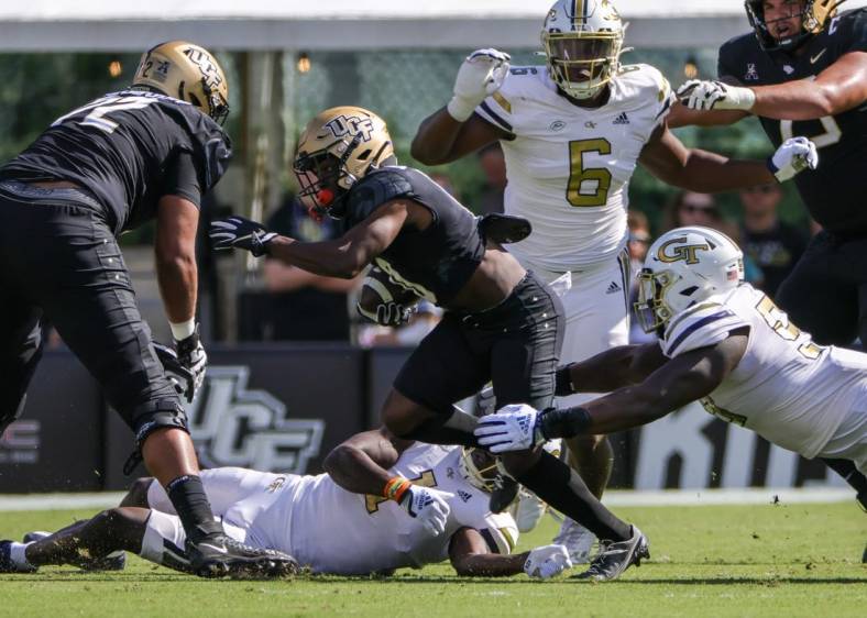 Sep 24, 2022; Orlando, Florida, USA; UCF Knights quarterback John Rhys Plumlee (10) is tackled by Georgia Tech Yellow Jackets defensive lineman D'Quan Douse (99) during the first quarter at FBC Mortgage Stadium. Mandatory Credit: Mike Watters-USA TODAY Sports
