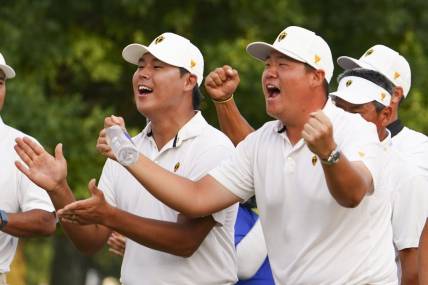 Sep 24, 2022; Charlotte, North Carolina, USA; International Team golfer Si Woo Kim (left) and golfer Sungjae Im (right) celebrate on the 18th green during the four-ball match play of the Presidents Cup golf tournament at Quail Hollow Club. Mandatory Credit: Peter Casey-USA TODAY Sports