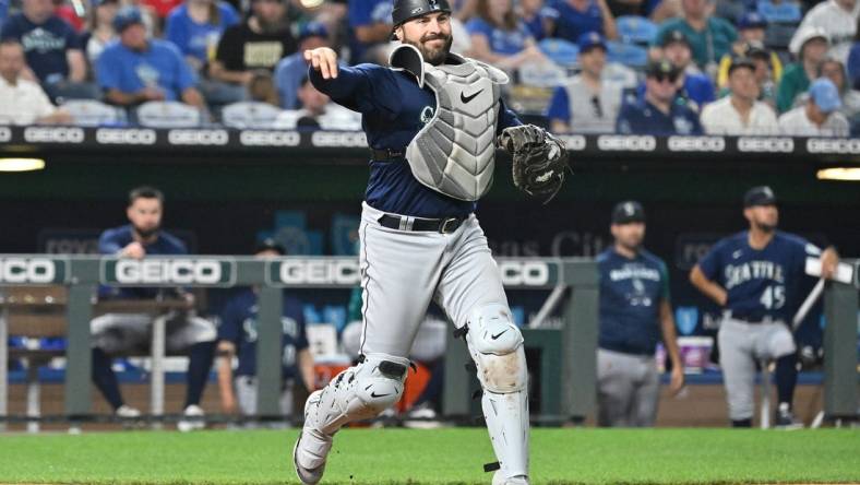 Sep 24, 2022; Kansas City, Missouri, USA;  Seattle Mariners catcher Curt Casali (5) throws to first base for an out during the fourth inning against the Kansas City Royals at Kauffman Stadium. Mandatory Credit: Peter Aiken-USA TODAY Sports