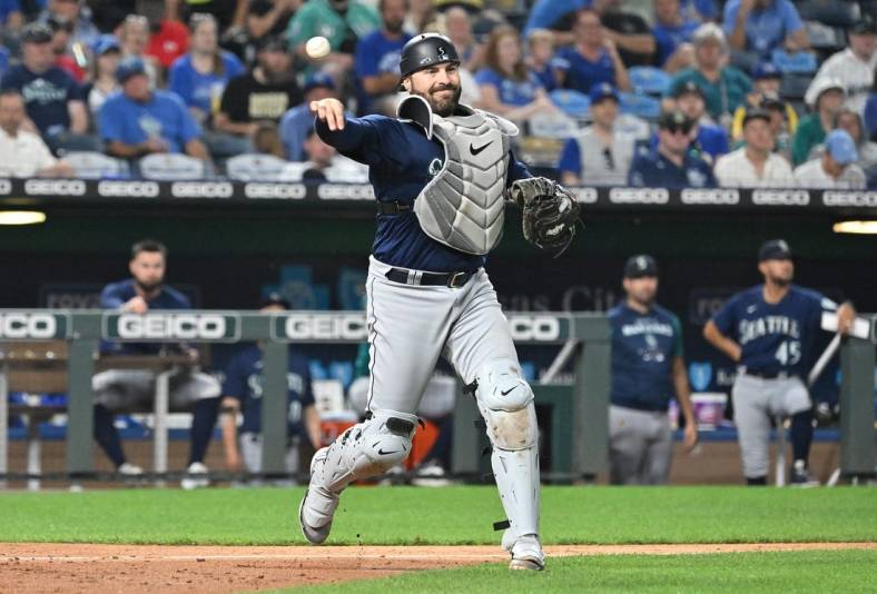 Sep 24, 2022; Kansas City, Missouri, USA;  Seattle Mariners catcher Curt Casali (5) throws to first base for an out during the fourth inning against the Kansas City Royals at Kauffman Stadium. Mandatory Credit: Peter Aiken-USA TODAY Sports