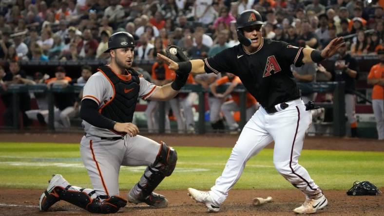 Sep 24, 2022; Phoenix, Arizona, USA; Arizona Diamondbacks right fielder Daulton Varsho (12) beats a throw to San Francisco Giants catcher Joey Bart (21) to score a run during the fourth inning at Chase Field. Mandatory Credit: Joe Camporeale-USA TODAY Sports