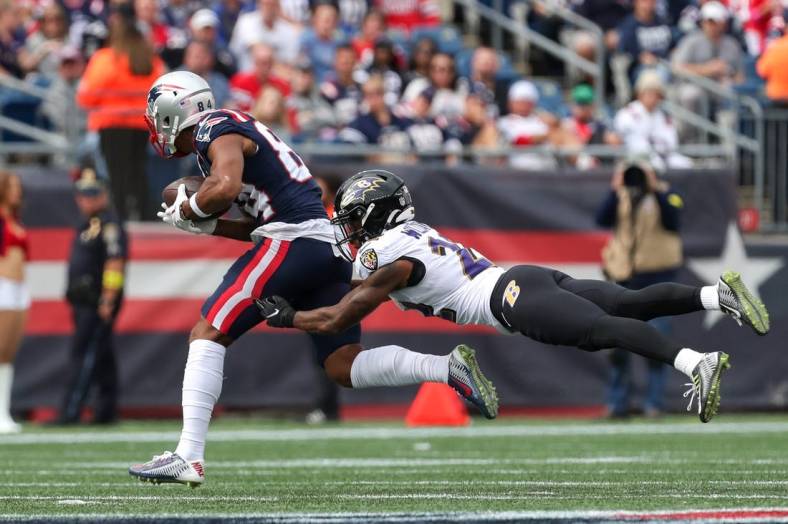 Sep 25, 2022; Foxborough, Massachusetts, USA; Baltimore Ravens cornerback Damarion Williams (22) tackles New England Patriots receiver Kendrick Bourne (84) during the first half at Gillette Stadium. Mandatory Credit: Paul Rutherford-USA TODAY Sports