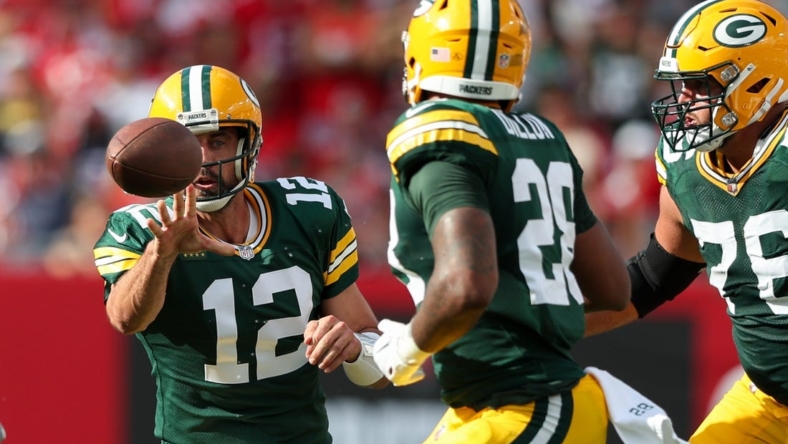 Sep 25, 2022; Tampa, Florida, USA;  Green Bay Packers quarterback Aaron Rodgers (12) shuffles a pass to running back AJ Dillon (28) against the Tampa Bay Buccaneers in the second quarter at Raymond James Stadium. Mandatory Credit: Nathan Ray Seebeck-USA TODAY Sports
