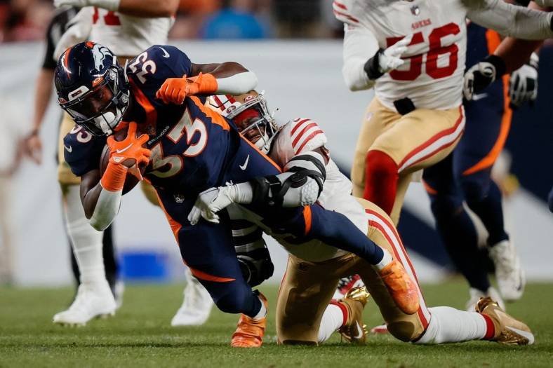 Sep 25, 2022; Denver, Colorado, USA; Denver Broncos running back Javonte Williams (33) is tackled by San Francisco 49ers linebacker Azeez Al-Shaair (51) in the second quarter at Empower Field at Mile High. Mandatory Credit: Isaiah J. Downing-USA TODAY Sports