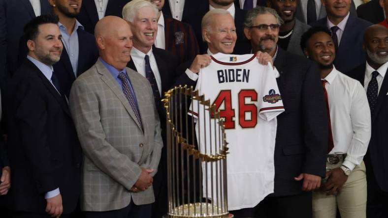 Sep 26, 2022; Washington, District of Columbia, US; President Joe Biden (M) holds a gift jersey while posing for a picture with (L-R) Atlanta Braves general manager and president of baseball operations Alex Anthopoulos, Braves manager Brian Snitker, and Braves chairman Terry McGuirk (M-L) during a ceremony honoring the 2021 World Series champion Braves in the East Room at The White House. Mandatory Credit: Geoff Burke-USA TODAY Sports