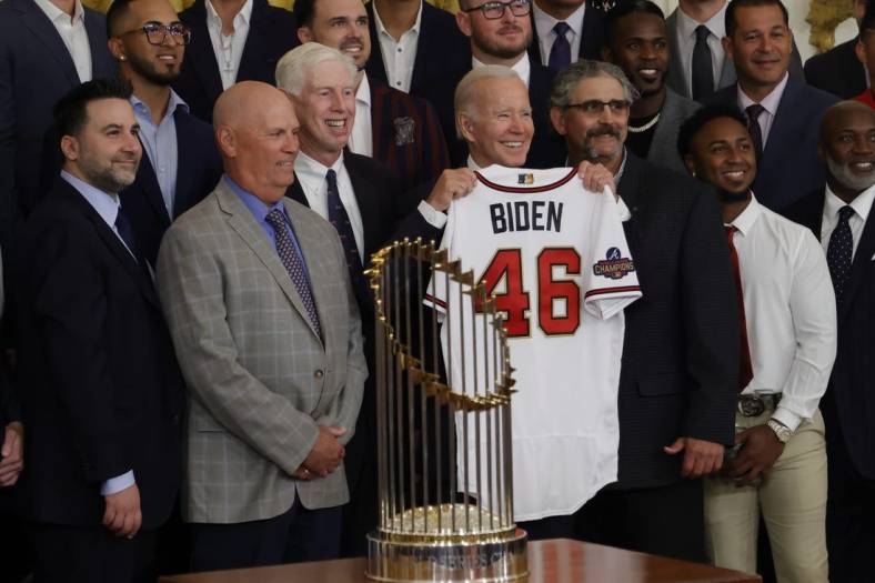 Sep 26, 2022; Washington, District of Columbia, US; President Joe Biden (M) holds a gift jersey while posing for a picture with (L-R) Atlanta Braves general manager and president of baseball operations Alex Anthopoulos, Braves manager Brian Snitker, and Braves chairman Terry McGuirk (M-L) during a ceremony honoring the 2021 World Series champion Braves in the East Room at The White House. Mandatory Credit: Geoff Burke-USA TODAY Sports