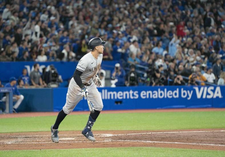 Sep 28, 2022; Toronto, Ontario, CAN; New York Yankees designated hitter Aaron Judge (99) hits his 61st home run scoring two runs against the Toronto Blue Jays during the seventh inning at Rogers Centre. Mandatory Credit: Nick Turchiaro-USA TODAY Sports