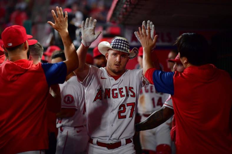 Sep 28, 2022; Anaheim, California, USA; Los Angeles Angels center fielder Mike Trout (27) is greeted after hitting a solo home run against the Oakland Athletics during the fourth inning at Angel Stadium. Mandatory Credit: Gary A. Vasquez-USA TODAY Sports