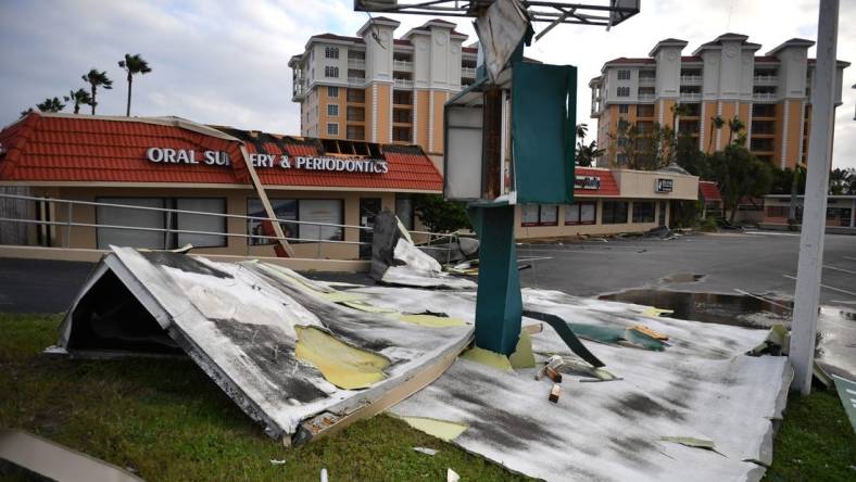 Roofing from a shopping center is wrapped around a sign at U.S. 41 and Tampa Ave. in Venice, Florida, following Hurricane Ian on Thursday, Sept. 29, 2022.

Sar Ian Venice 025