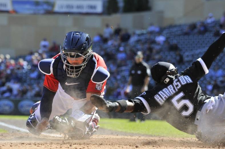 Sep 29, 2022; Minneapolis, Minnesota, USA; Chicago White Sox third baseman Josh Harrison (5) slides in safe at home plate as Minnesota Twins catcher Gary Sanchez (24) attempts to apply the tag during the third inning at Target Field. Mandatory Credit: Jeffrey Becker-USA TODAY Sports