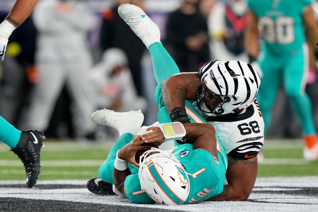 Sep 29, 2022; Cincinnati, Ohio, USA; Cincinnati Bengals defensive tackle Josh Tupou (68) sacks Miami Dolphins quarterback Tua Tagovailoa (1) in the second quarter at Paycor Stadium in Cincinnati. Tagovailoa sustained a head injury on the play and left the game for treatment. Mandatory Credit: Kareem Elgazzar-USA TODAY Sports