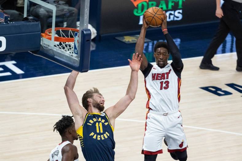 Mar 31, 2021; Indianapolis, Indiana, USA; Miami Heat center Bam Adebayo (13) rebounds the ball over Indiana Pacers forward Domantas Sabonis (11) during the first quarter at Bankers Life Fieldhouse. Mandatory Credit: Trevor Ruszkowski-USA TODAY Sports