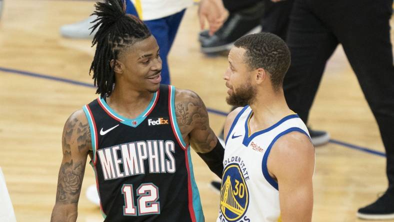 May 16, 2021; San Francisco, California, USA; Memphis Grizzlies guard Ja Morant (12) talks to Golden State Warriors guard Stephen Curry (30) after the game at Chase Center. Mandatory Credit: Kyle Terada-USA TODAY Sports