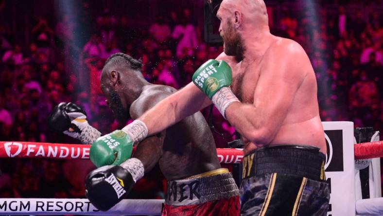 Oct 9, 2021; Las Vegas, Nevada, USA; Deontay Wilder (red/black trunks) is knocked out by Tyson Fury (black/gold trunks) during their WBC/Lineal heavyweight championship boxing match at T-Mobile Arena. Mandatory Credit: Joe Camporeale-USA TODAY Sports