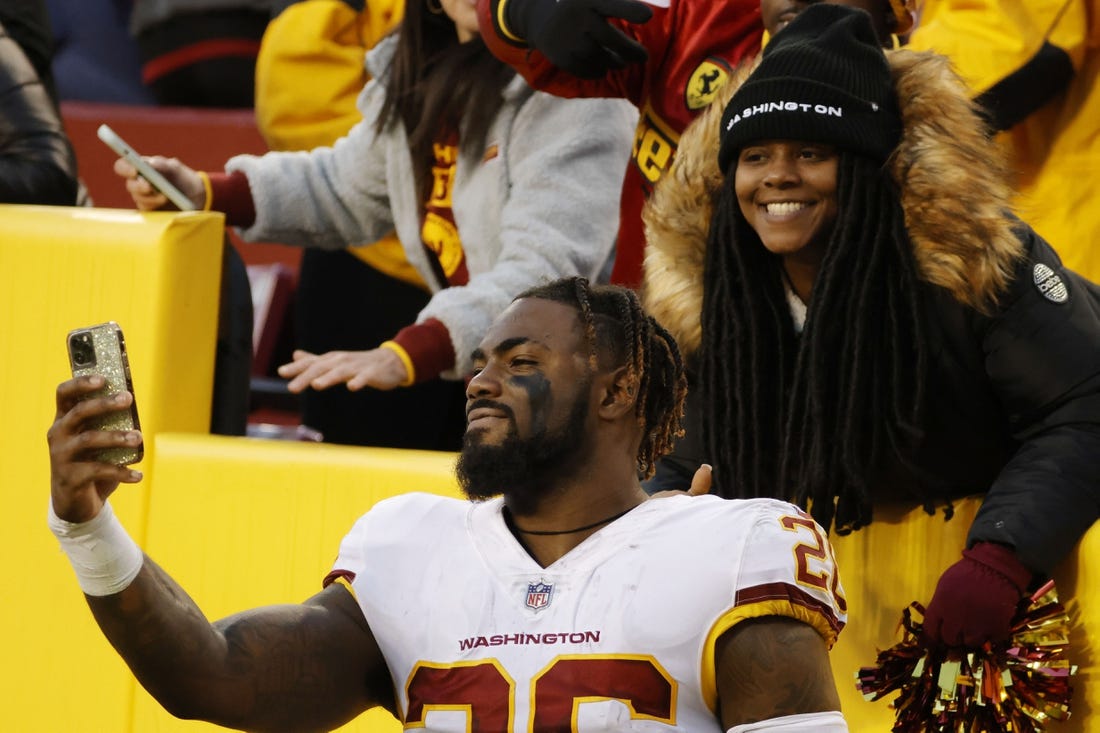 Dec 12, 2021; Landover, Maryland, USA; Washington Football Team safety Landon Collins (26) takes a selfie with a fan after the game against the Dallas Cowboys at FedExField. Mandatory Credit: Geoff Burke-USA TODAY Sports