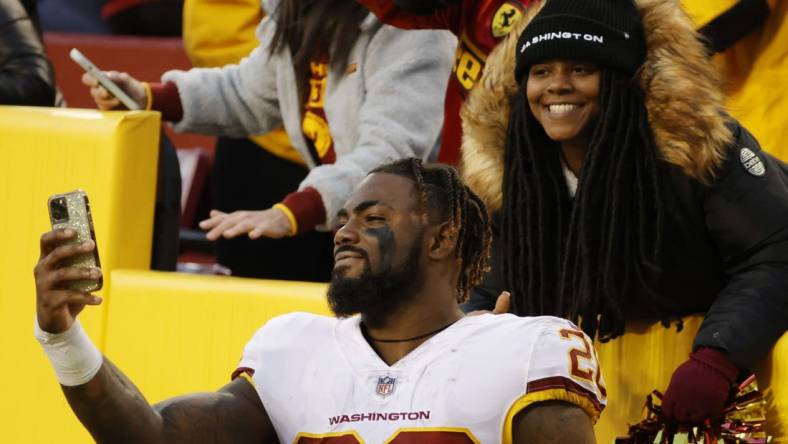 Dec 12, 2021; Landover, Maryland, USA; Washington Football Team safety Landon Collins (26) takes a selfie with a fan after the game against the Dallas Cowboys at FedExField. Mandatory Credit: Geoff Burke-USA TODAY Sports