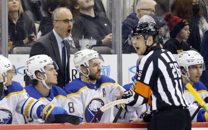 Dec 17, 2021; Pittsburgh, Pennsylvania, USA;  Buffalo Sabres head coach Don Granato (left) reacts to referee Jake Brenk (26) against the Pittsburgh Penguins during the first period at PPG Paints Arena. Mandatory Credit: Charles LeClaire-USA TODAY Sports