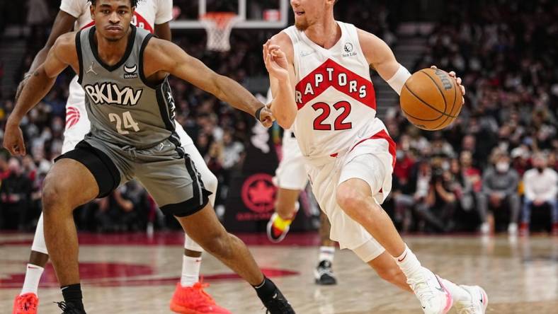 Mar 1, 2022; Toronto, Ontario, CAN; Toronto Raptors guard Malachi Flynn (22) drives to the net against Brooklyn Nets guard Cam Thomas (24) during the second half at Scotiabank Arena. Mandatory Credit: John E. Sokolowski-USA TODAY Sports