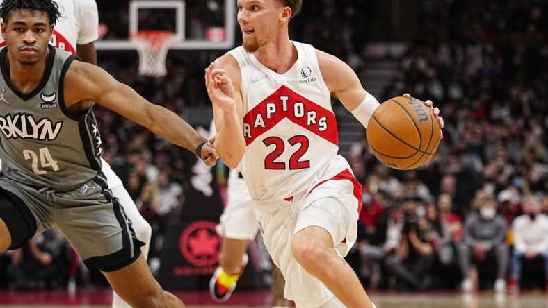 Mar 1, 2022; Toronto, Ontario, CAN; Toronto Raptors guard Malachi Flynn (22) drives to the net against Brooklyn Nets guard Cam Thomas (24) during the second half at Scotiabank Arena. Mandatory Credit: John E. Sokolowski-USA TODAY Sports