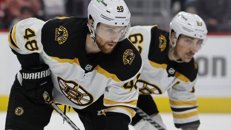 Apr 5, 2022; Detroit, Michigan, USA;  Boston Bruins defenseman Matt Grzelcyk (48) and left wing Brad Marchand (63) gets set during a face off in the second period against the Detroit Red Wings at Little Caesars Arena. Mandatory Credit: Rick Osentoski-USA TODAY Sports