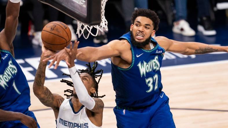 Apr 29, 2022; Minneapolis, Minnesota, USA; Minnesota Timberwolves center Karl-Anthony Towns (32) blocks Memphis Grizzlies guard Ja Morant (12) in the fourth quarter during game six of the first round for the 2022 NBA playoffs at Target Center. Mandatory Credit: Brad Rempel-USA TODAY Sports