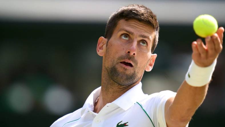 Jul 5, 2022; London, England, United Kingdom; Novak Djokovic (SRB) serves against Jannik Sinner (ITA) during a quarterfinals mens singles match on Centre court at the 2022 Wimbledon Championships at All England Lawn Tennis and Croquet Club. Mandatory Credit: Peter van den Berg-USA TODAY Sports