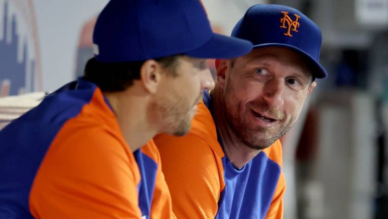 Aug 4, 2022; New York City, New York, USA; New York Mets starting pitchers Jacob deGrom (left) and Max Scherzer talk in the dugout during the ninth inning against the Atlanta Braves at Citi Field. Mandatory Credit: Brad Penner-USA TODAY Sports