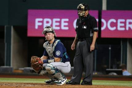 Aug 12, 2022; Arlington, Texas, USA; Seattle Mariners catcher Cal Raleigh (29) looks to the dugout as umpire Jerry Meals (41) looks on in the second inning against the Texas Rangers at Globe Life Field. Mandatory Credit: Tim Heitman-USA TODAY Sports