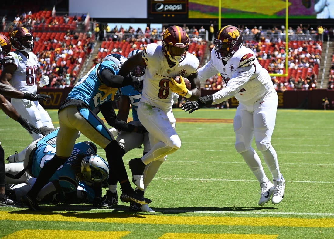 Aug 13, 2022; Landover, Maryland, USA; Washington Commanders running back Brian Robinson (8) scores a touchdown  past Carolina Panthers defensive tackle Daviyon Nixon (54) during the first half at FedExField. Mandatory Credit: Brad Mills-USA TODAY Sports