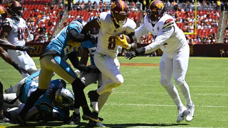 Aug 13, 2022; Landover, Maryland, USA; Washington Commanders running back Brian Robinson (8) scores a touchdown  past Carolina Panthers defensive tackle Daviyon Nixon (54) during the first half at FedExField. Mandatory Credit: Brad Mills-USA TODAY Sports