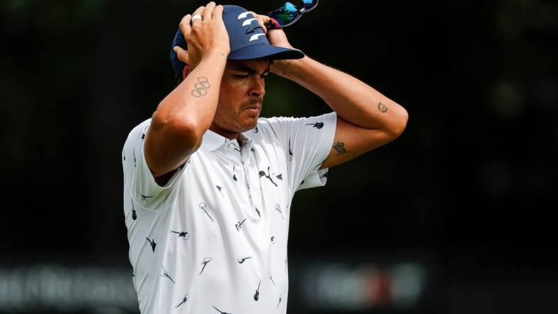 Rickie Fowler puts on his cap as he walks off the 9th green during Round 1 of the Rocket Mortgage Classic at the Detroit Golf Club in Detroit on Thurs., July 28, 2022.

Syndication Detroit Free Press