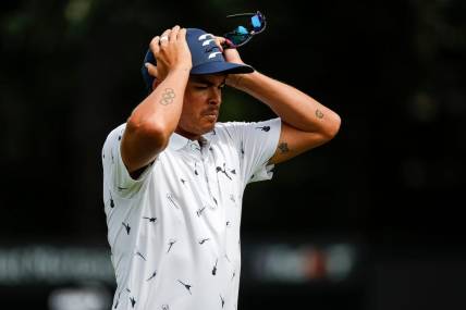 Rickie Fowler puts on his cap as he walks off the 9th green during Round 1 of the Rocket Mortgage Classic at the Detroit Golf Club in Detroit on Thurs., July 28, 2022.

Syndication Detroit Free Press