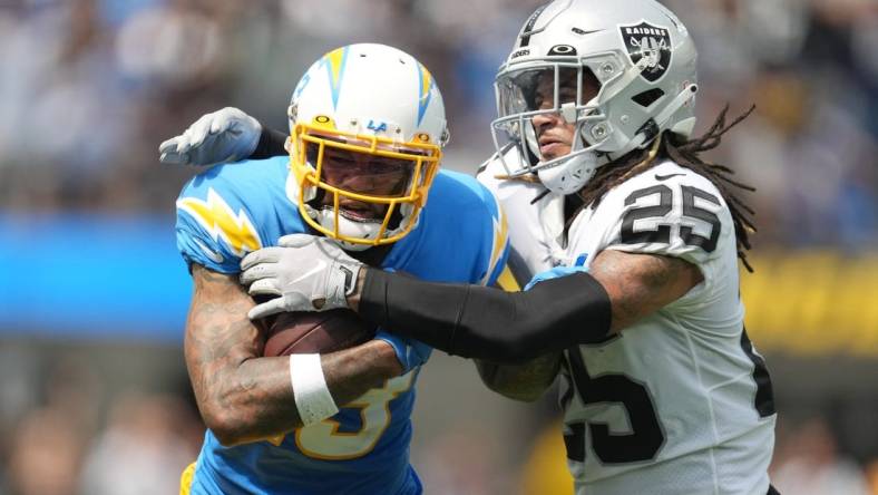 Sep 11, 2022; Inglewood, California, USA; Los Angeles Chargers wide receiver Keenan Allen (13) tries to break free from the grasp of Las Vegas Raiders safety Tre'von Moehrig (25) in the first half at SoFi Stadium. Mandatory Credit: Kirby Lee-USA TODAY Sports