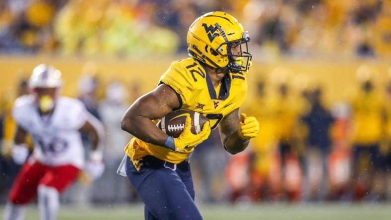 Sep 10, 2022; Morgantown, West Virginia, USA; West Virginia Mountaineers running back CJ Donaldson (12) runs the ball during the third quarter against the Kansas Jayhawks at Mountaineer Field at Milan Puskar Stadium. Mandatory Credit: Ben Queen-USA TODAY Sports