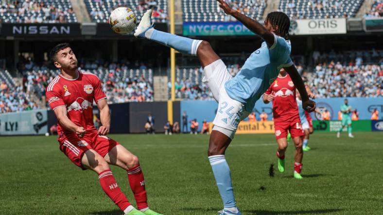 Sep 17, 2022; New York, New York, USA; New York City FC defender Tayvon Gray (24) kicks the ball against New York Red Bulls midfielder Lewis Morgan (10) at Yankee Stadium. Mandatory Credit: Vincent Carchietta-USA TODAY Sports