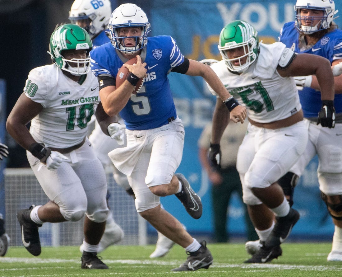 Memphis Tigers quarterback Seth Henigan (5) keeps hold of the ball as North Texas Mean Green defensive tackle Roderick Brown (10) and North Texas Mean Green defensive lineman Fatafehi Vailea (51) guard him during a Memphis Tigers game against the North Texas Mean Green on Saturday, Sept. 24, 2022, at Simmons Bank Liberty Stadium in Memphis. Memphis defeated North Texas 44-34.