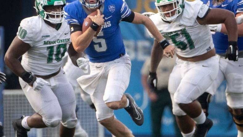 Memphis Tigers quarterback Seth Henigan (5) keeps hold of the ball as North Texas Mean Green defensive tackle Roderick Brown (10) and North Texas Mean Green defensive lineman Fatafehi Vailea (51) guard him during a Memphis Tigers game against the North Texas Mean Green on Saturday, Sept. 24, 2022, at Simmons Bank Liberty Stadium in Memphis. Memphis defeated North Texas 44-34.