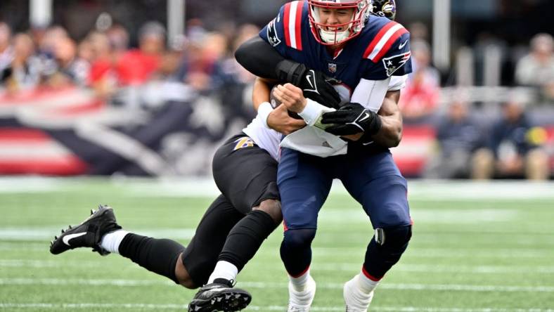 Sep 25, 2022; Foxborough, Massachusetts, USA; New England Patriots quarterback Mac Jones (10) is tackled by Baltimore Ravens linebacker Odafe Oweh (99) during the first half at Gillette Stadium. Mandatory Credit: Brian Fluharty-USA TODAY Sports